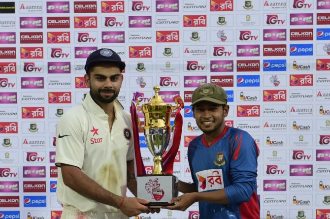 Kohli (left) and Rahim (right) pose with the trophy after the one-off Test ended as a draw