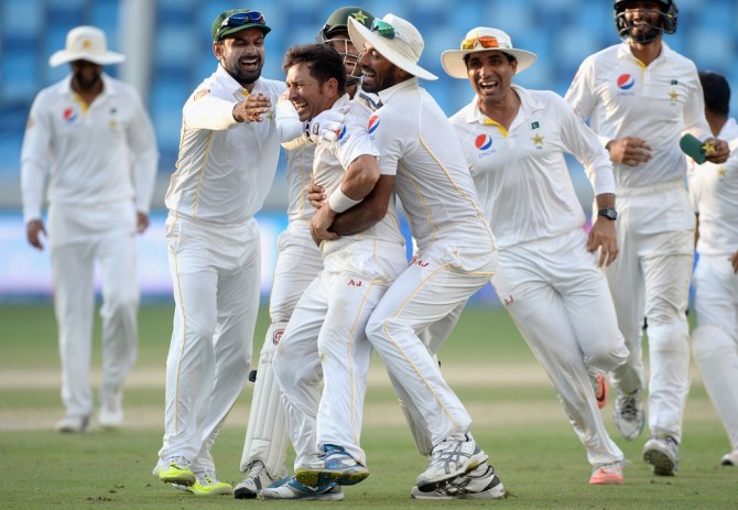 Shah is mobbed by his team-mates after leading Pakistan to victory